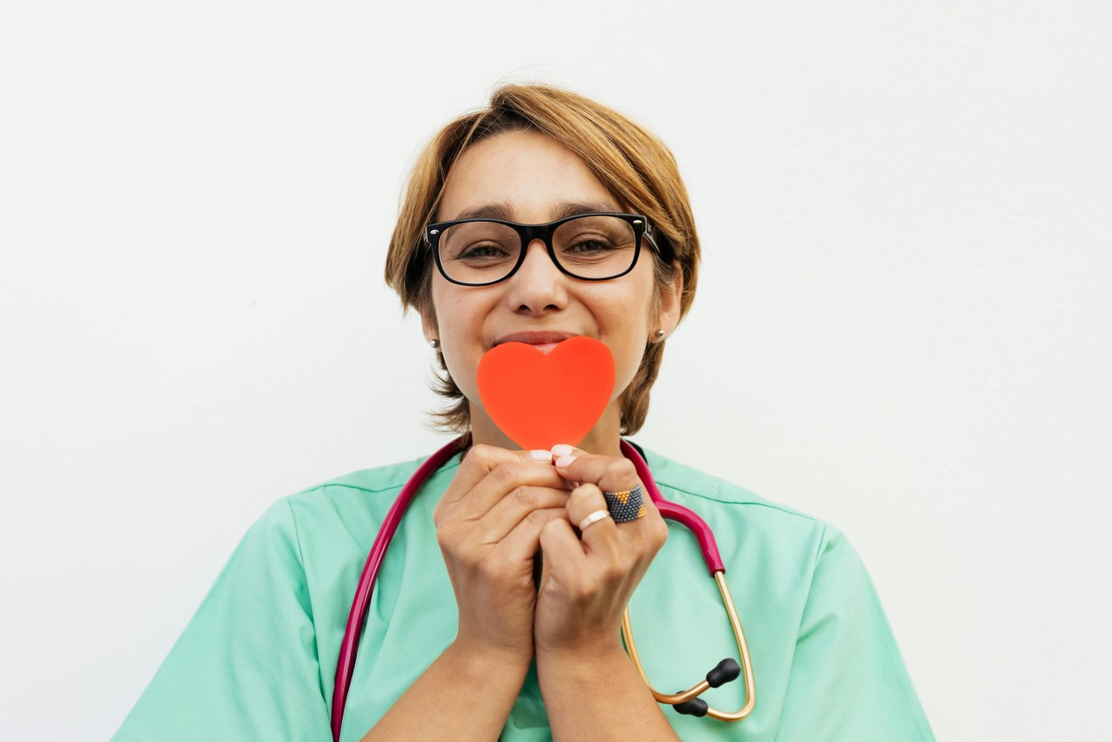 Doctor holding a red heart symbol, promoting healthcare compassion.
